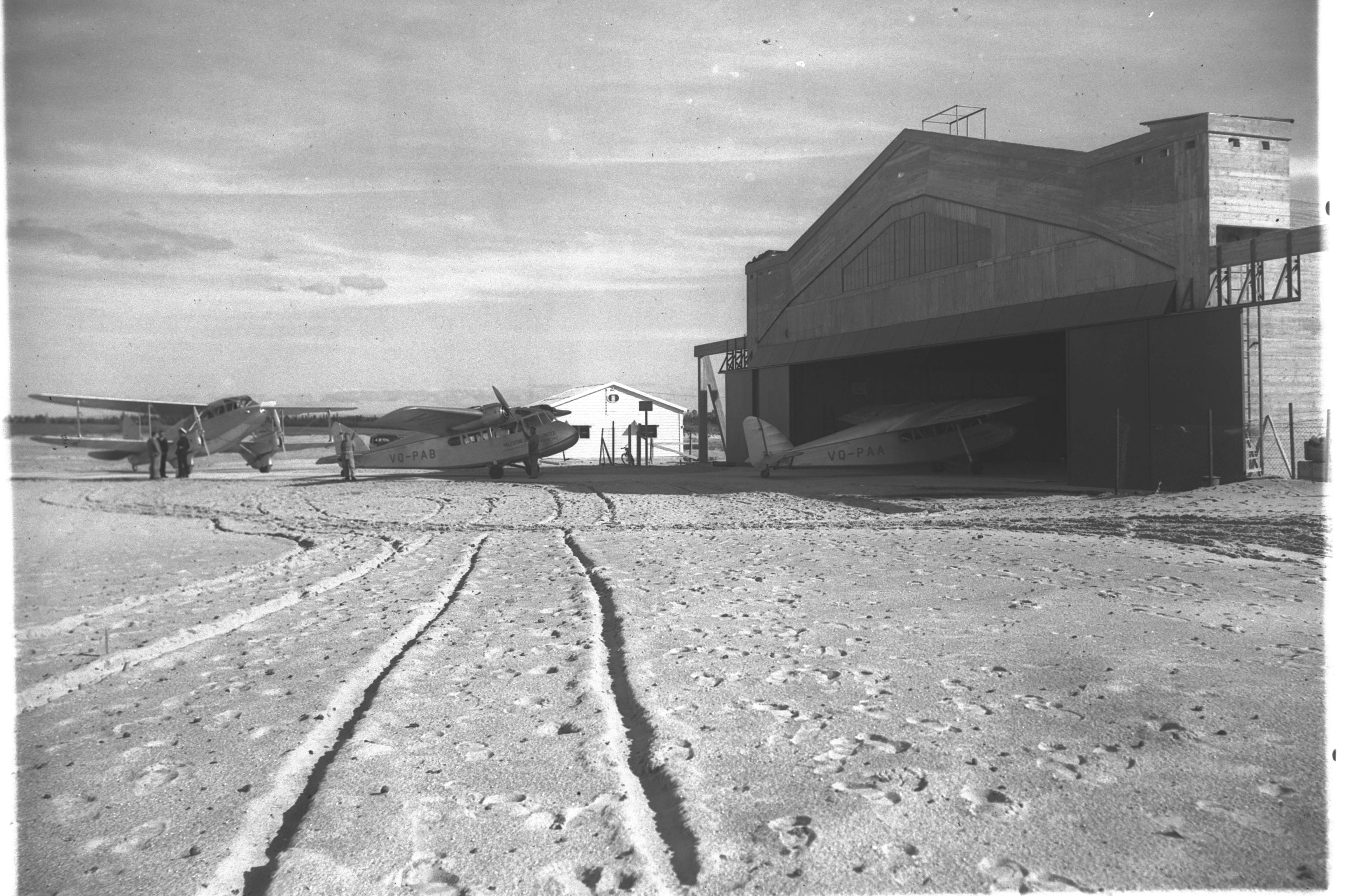 The main hangar at Dov Hoz airfield near Tel Aviv in 1938, with light aircraft on the sand and one inside the shed